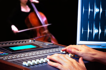 sound engineer hands working on digital sound mixer for cello recording © princeoflove
