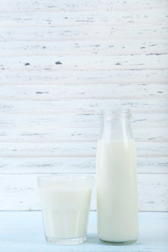 Glass and bottle of milk on wooden table