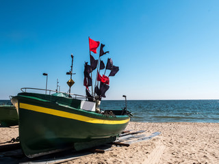 Fishing boat stretched out to the sandy shore - obrazy, fototapety, plakaty