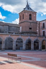 Fototapeta premium Mercado Chico square, with a view of the San Juan Bautista's church bell tower, and a bench.