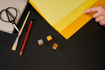 Hand choosing yellow shade with creativity tools on black