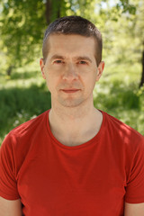 The man in a red t-shirt and jeans in the park