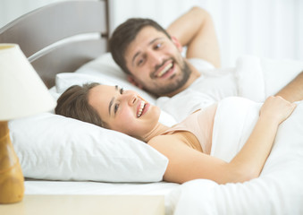 The happy couple lay in the comfortable bed