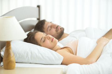 Fototapeta na wymiar The couple sleeping in the comfortable bed