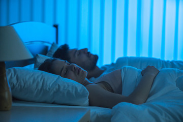 The young couple sleeping on the bed. night time