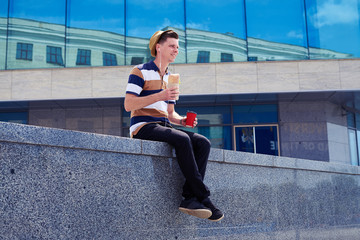 Smiling guy in headphones enjoying lunchtime outdoors