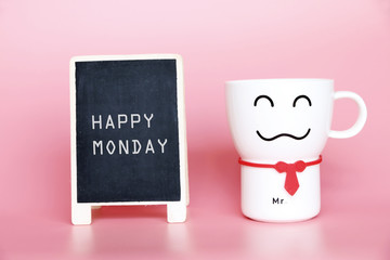 Happy Monday text on blackboard and Coffee cup smiling 