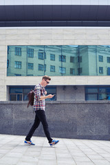 Cheerful man listening to the music while walking in the downtown