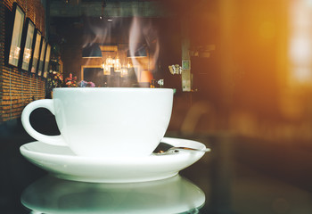 cup of coffee and smoke on table in cafe.