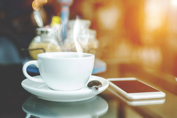 cup of coffee and telephone on table in cafe,Soft focus