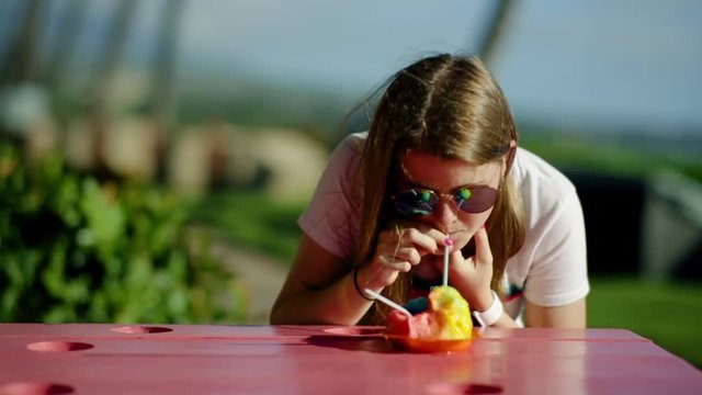 Teen Girl Uses A Straw To Drink Her Melting Hawaiian Shaved Ice, Slow Motion, Maui, Hawaii