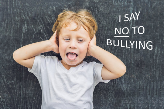 Little Boy Standing Up For Himself And Saying NO To Bullying By Blowing A Raspberry At The Bully In Front Of A Blackboard At School