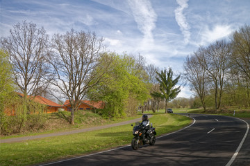 Motorcyclist and car on asphalt road