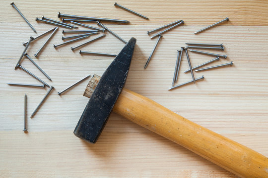 Hammer and nails laid on the board