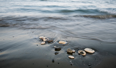 Pebbles in the beach and flowing sea water