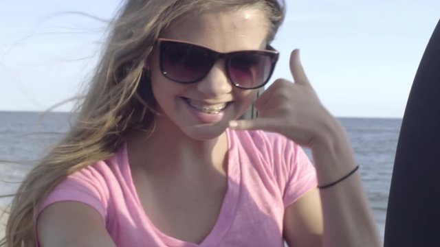 Teen Girl Takes Fun Selfies With Smart Phone In Backseat Of Moving Jeep, On Beach 