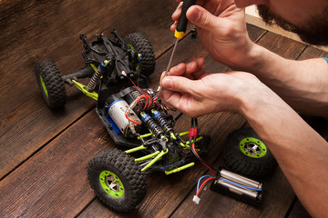 Rc radio control car crawler model toy electronics repair. Green toy suv in repairshop workplace, free space