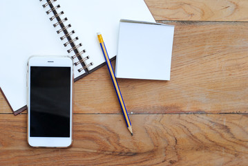 Telephone and notebook on the wooden floor.
