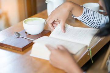 woman reading book in coffee shop