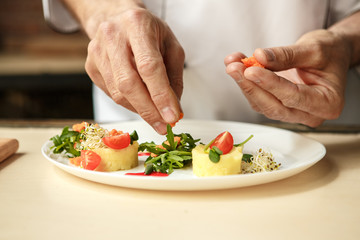  Mature man professional chef cooking meal indoors