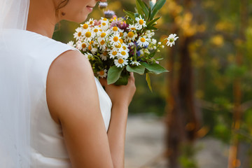 Obraz na płótnie Canvas Summer wedding bouquet made of chamomile flowers in hand