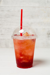 Lemonade in a plastic glass with fruit