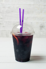 Lemonade in a plastic glass with fruit