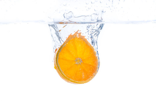 orange slice in water splash. white  background