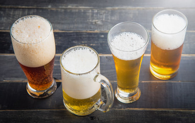 Beer glasses with various beer on old wood table