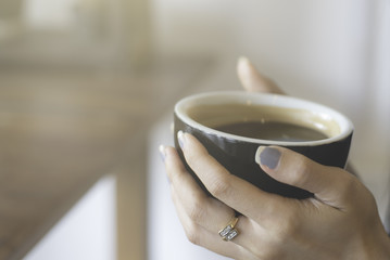 Woman hand hold hot black coffee cup 
