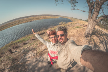 Couple taking selfie on Chobe River, Namibia Botswana border, Africa. Fisheye view from above,...