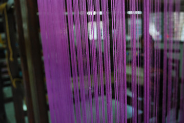 Yarn in purple color made by Thai weaving loom