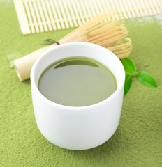 Green matcha tea in a bowl and bamboo whiskon