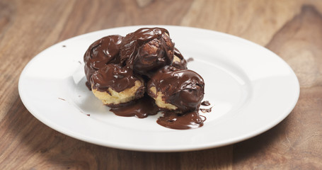 profiteroles with fine dark chocolate on plate