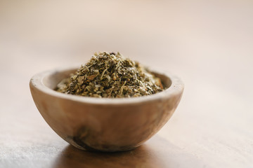 dried provence herb mix in wood bowl for seasoning on table