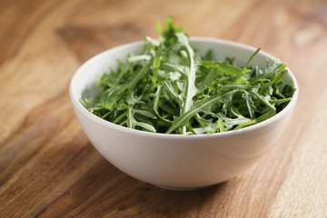 fresh green rocket salad arugula leaves in white bowl