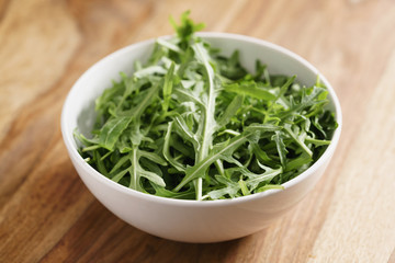 fresh green rocket salad arugula leaves in white bowl