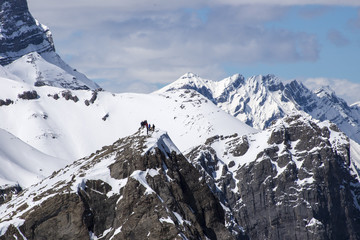 Group of hikers on top of snowy mountain peak in Canadian Rockies