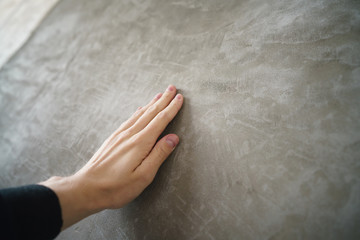 young man hand touching concrete wall - obrazy, fototapety, plakaty