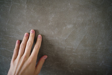 young man hand touching concrete wall