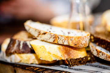 The different slices of bread with grains are on the Board and olive oil.