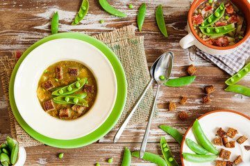 Bean soup in bowl with fresh green pea pods and rye toasts