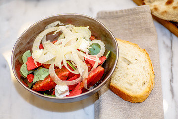 Salad of tomatoes and onions is in the bowl.