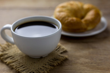Coffee and croissants on the black wooden