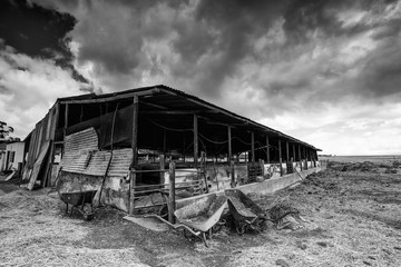 Wide angle view of old buildings and farm instruments on an old abandoned farm