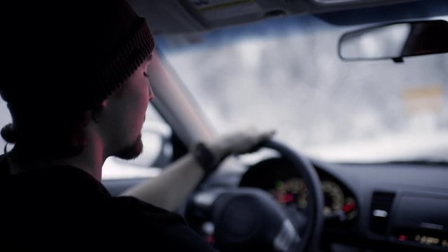 Slow Motion Closeup Of Young Man Driving On Mountain Road In Winter