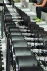 Fototapeta na wymiar Black and Steel Dumbbells in Gym: Weight Fitness Equipment