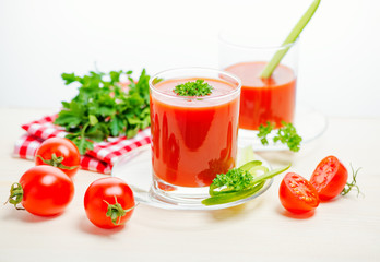 tomato juice in transparent glasses with parsley, cucumber and red napkin, concept healthy eating, close up