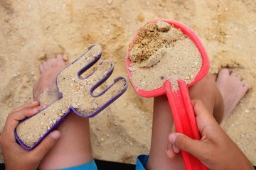 Little hands holding beach toys