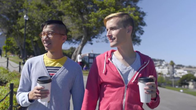 Gay Couple Enjoy Coffee And A Walk In Dolores Park, San Francisco